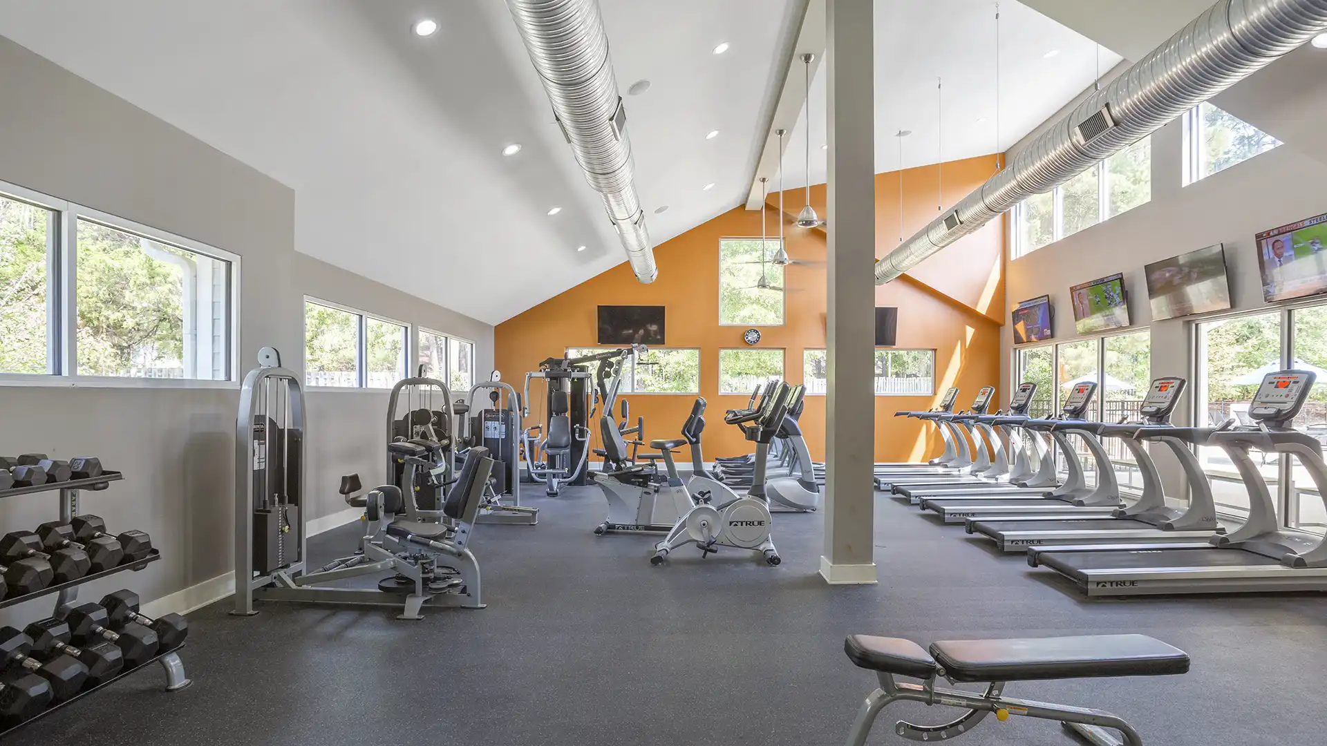 modern fitness center with free weights, cardio machines, strength stations and more