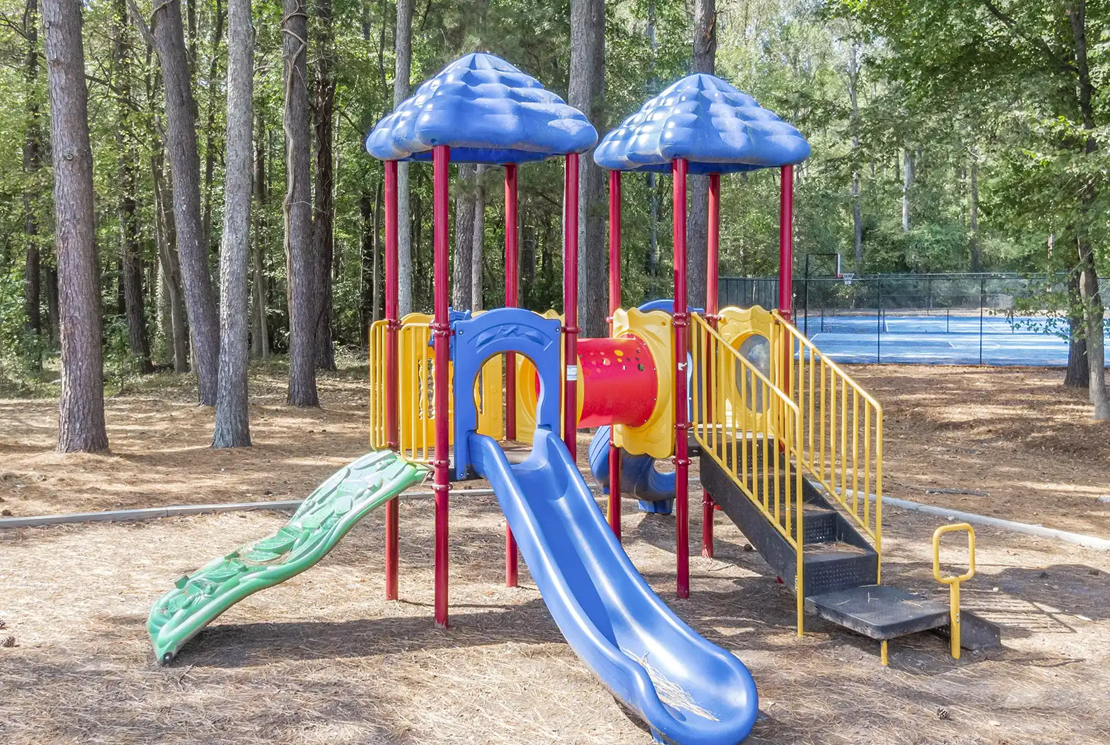 Playground in wooded area near tennis courts