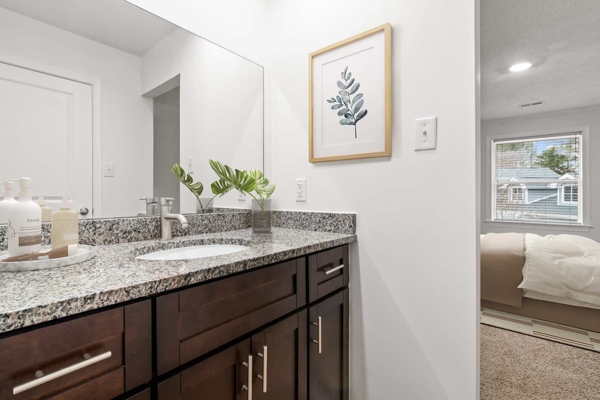 bathroom with granite counters and wall art