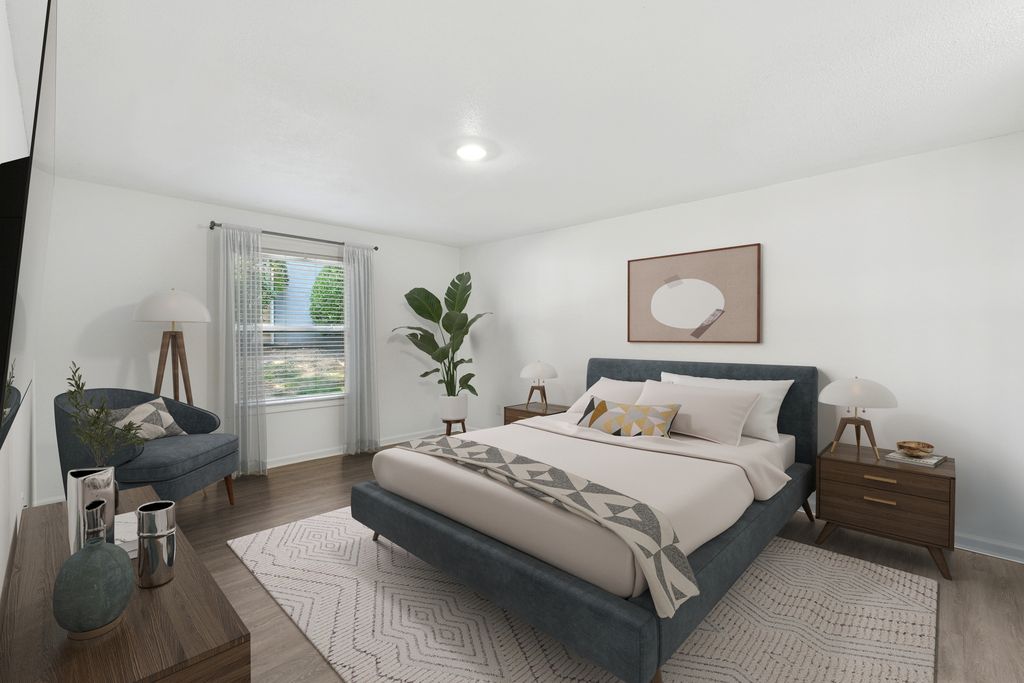 Elegant bedroom with a plush bed, stylish decor, and abundant natural light from a large window, offering a serene and cozy retreat.