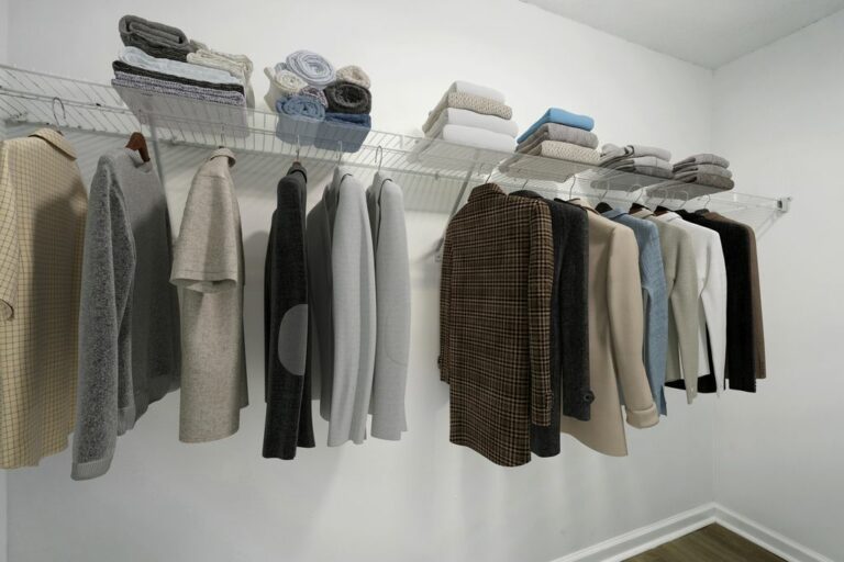 Elegant closet space with organized clothing and neatly stacked towels showcasing modern living organization.